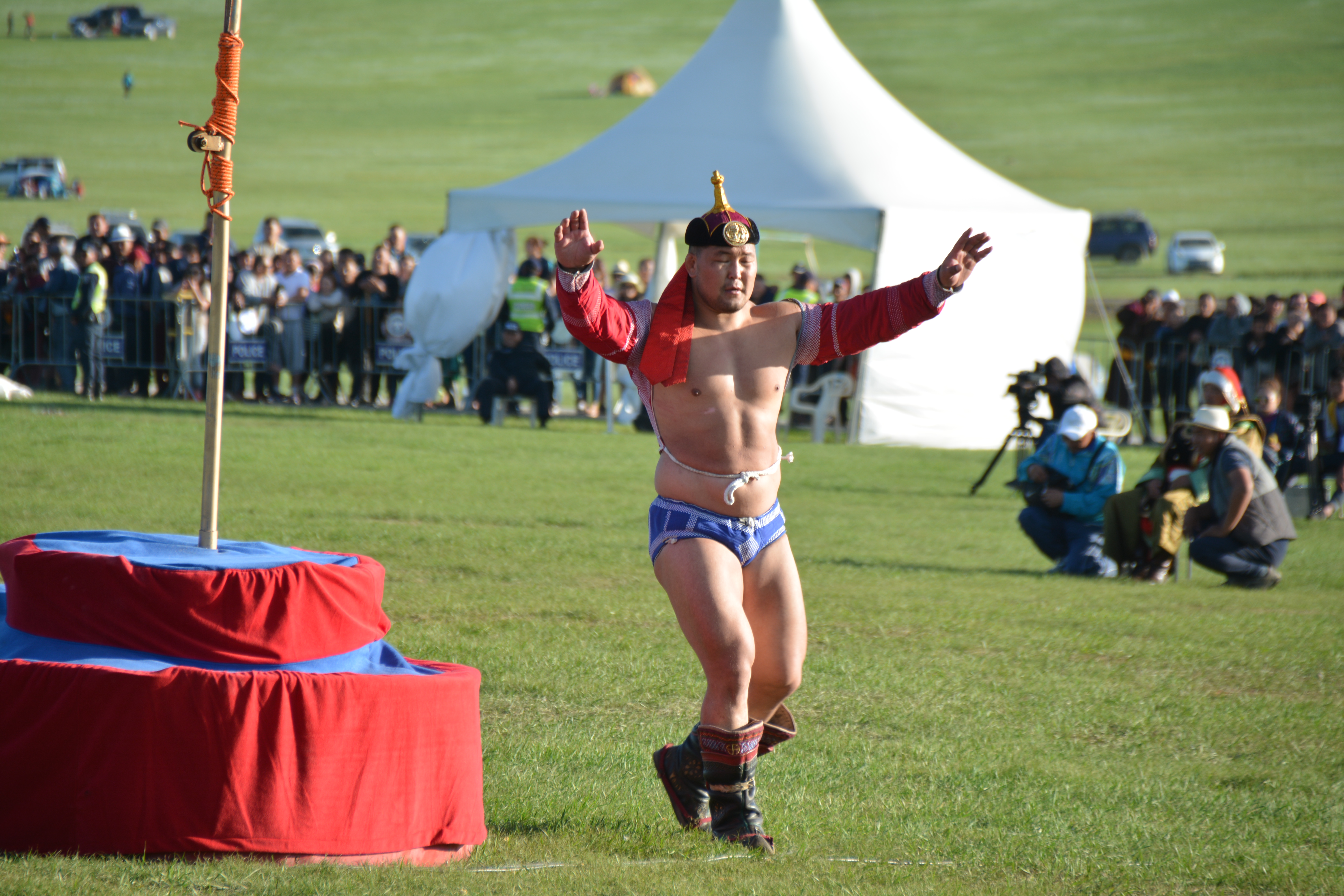 Mongolian wrestler performing the traditional eagle dance after victory during a Naadam wrestling competition